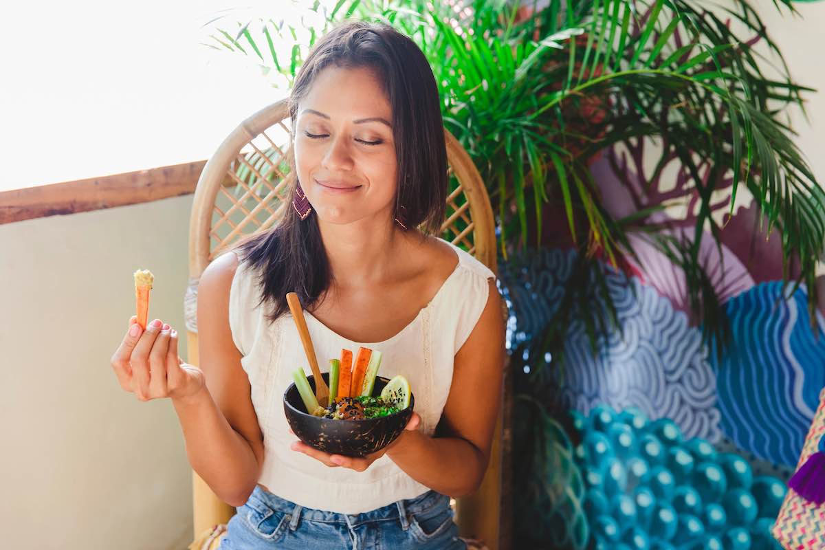 Woman sitting and eating carrots